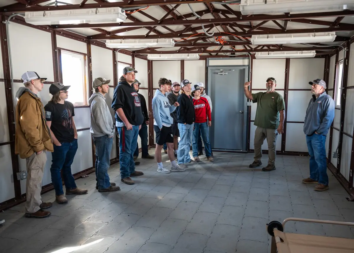 Kevin Forshey, an engineer technician at the Contingency Basing Integration and Technology Evaluation Center, explains to Waynesville Career Center students how the temporary structure they are inside is made to be easily constructed and broke down. 
