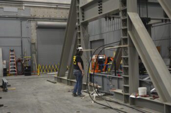 Dr. Kennan Crane, research civil engineer in the U.S. Army Engineer Research and Development Center’s Geotechnical and Structures Laboratory, inspects a modular ramp system at the Structural Strong Floor during testing on May 24. (U.S. Army Corps of Engineers photo)
